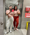 Two Women Pose with Period Products in Bathroom with Mirror Cling Signage